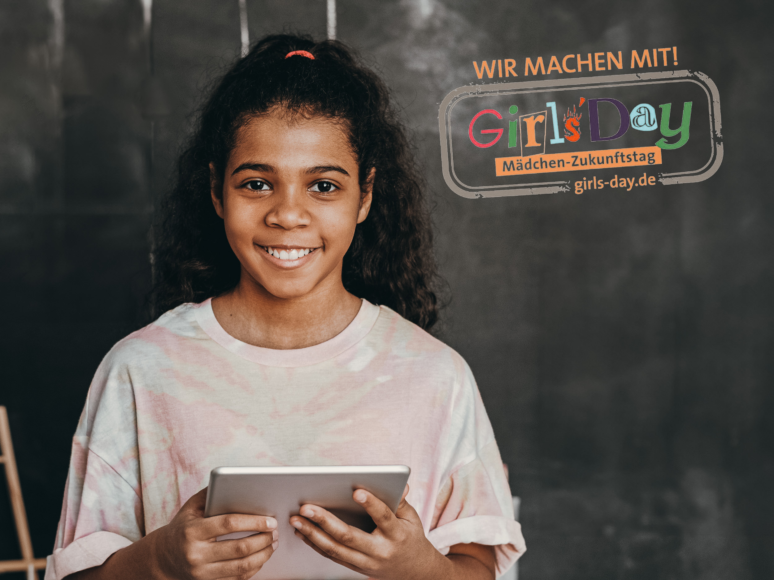 Mädchen mit Tablet, Text: Wir machen mit! Girls'Day Mädchen-Zukunftstag, girls-day.de